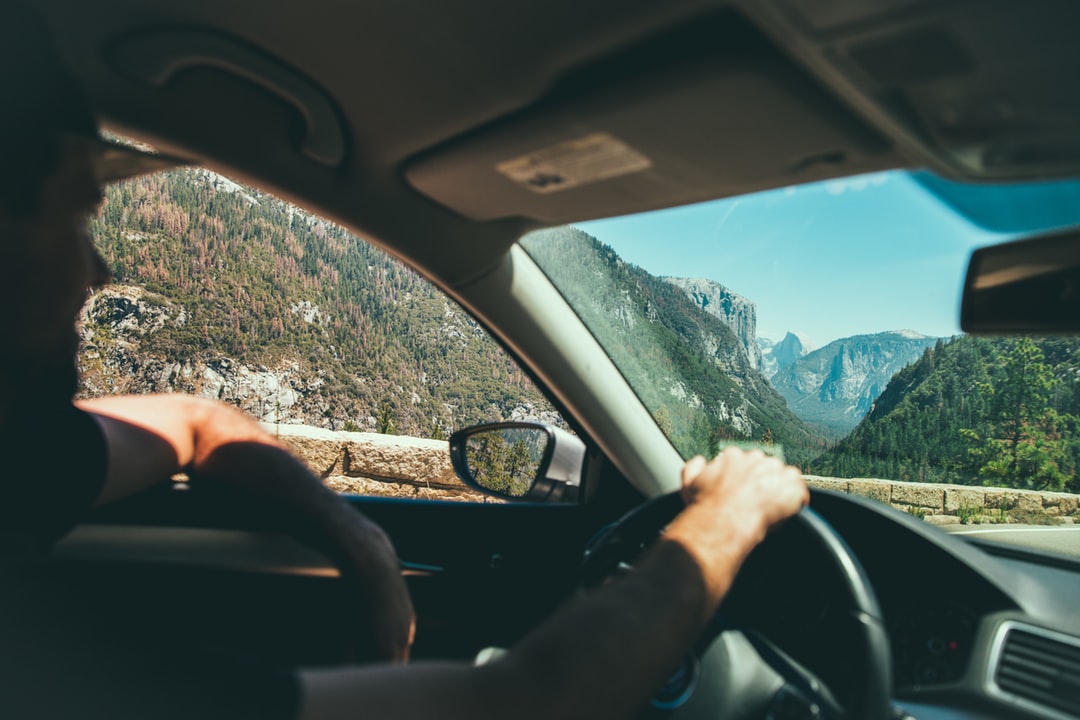 山間を運転する男性